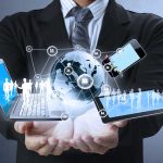 Businessman holding digital devices and globe hologram