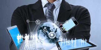 Businessman holding digital devices and globe hologram