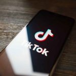TikTok logo on smartphone screen on table