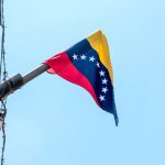 Venezuelan flag flying on a pole.