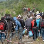 Group of people walking through rural area.