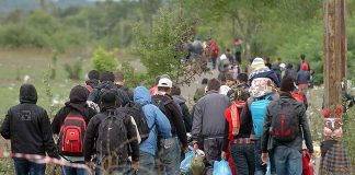 Group of people walking through rural area.