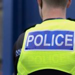 Police officer wearing a bright yellow vest.