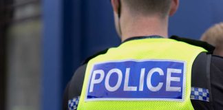 Police officer wearing a bright yellow vest.