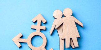 Wooden gender symbol and figures on blue background