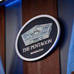 Pentagon emblem between two flags in Washington office