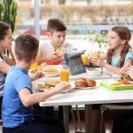 Kids eating lunch together at a table.