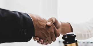 Handshake over a table with a gavel.