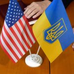 American and Ukrainian flags on wooden table meeting