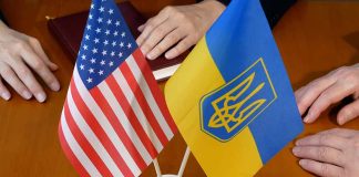 American and Ukrainian flags on wooden table meeting