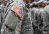 People in camouflage uniforms with US flag patch