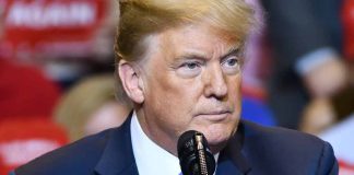 Man speaking at a rally in blue suit