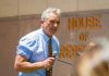 Man speaking into microphone outside building
