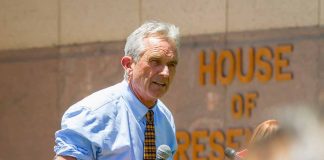 Man speaking into microphone outside building