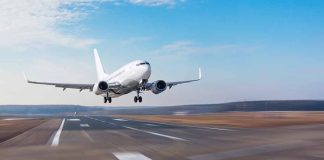 Airplane taking off from runway against blue sky