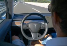 Person in Tesla car on autopilot, hands-free driving.