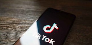 TikTok logo on smartphone screen on table