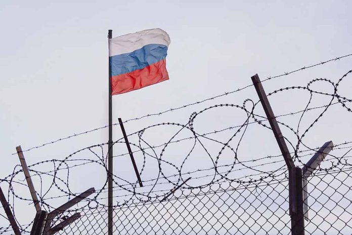 2148395873 featured image Barbed wire fence with a Russian flag above
