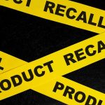 Yellow tape with product recall text on black background