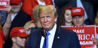 Person at a rally with Make America Great Again signs