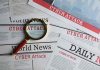 Newspapers with Cyber Attack headlines and a magnifying glass