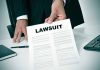 Person holding a document labeled Lawsuit