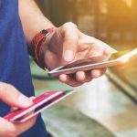 Person holding smartphone and credit card outside