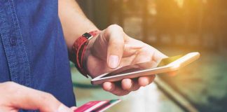 Person holding smartphone and credit card outside