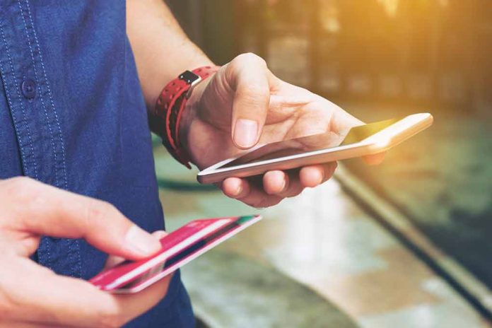 540545581 featured image Person holding smartphone and credit card outside