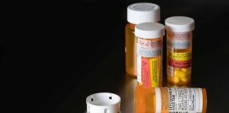 Prescription medicine bottles and scattered white pills