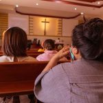 People sitting in church pews during service