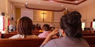 People sitting in church pews during service