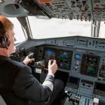 Pilot in cockpit operating airplane controls
