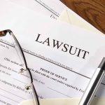 ADA Lawsuit SLAMS Bank Over Chilling Office Stunt Lawsuit papers with glasses and pen on table