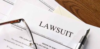 Lawsuit papers with glasses and pen on table