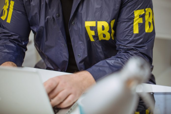 612694235 featured image Person wearing FBI jacket using a laptop