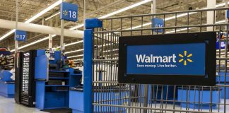 Walmart shopping cart inside store near checkout aisl
