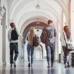 Four students walking in a corridor together