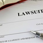 Lawsuit document with a pen and book