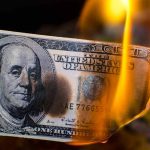 Burning hundred dollar bill with visible flames