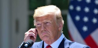 Man in a suit adjusting an earpiece