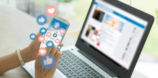 Person using smartphone and laptop with social media icons