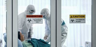 Healthcare workers in protective gear in quarantine room