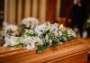 Flower arrangement on a wooden casket at a funeral