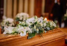 Flower arrangement on a wooden casket at a funeral