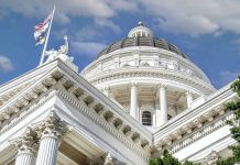 Capitol building dome and flags under a blue sky