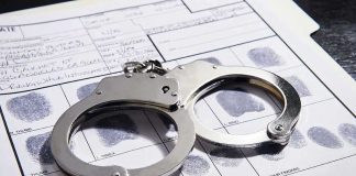 Handcuffs on fingerprint form with fingerprints visible