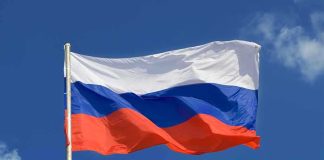 The flag of Russia waving against a clear blue sky