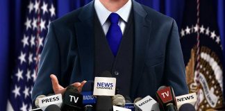 A speaker at a press conference with multiple microphones in front of them