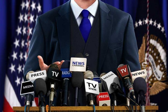 shutterstock_240517264.jpg A speaker at a press conference with multiple microphones in front of them